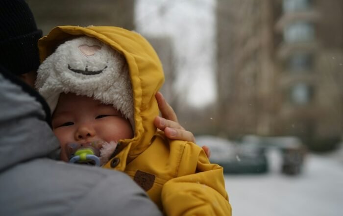 Bebê agasalhado com casaco amarelo em um dia frio
