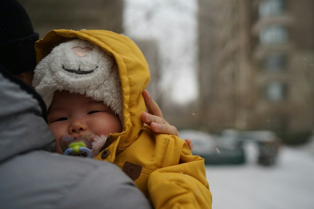 Bebê agasalhado com casaco amarelo em um dia frio