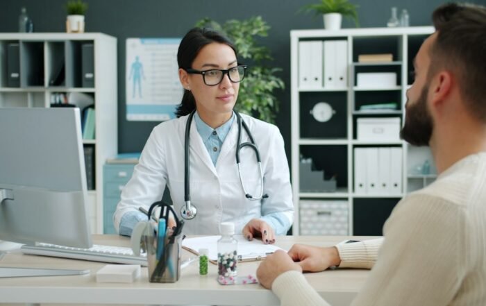Médica conversando com um adolescente durante consulta no consultório