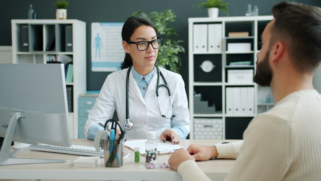 Médica conversando com um adolescente durante consulta no consultório