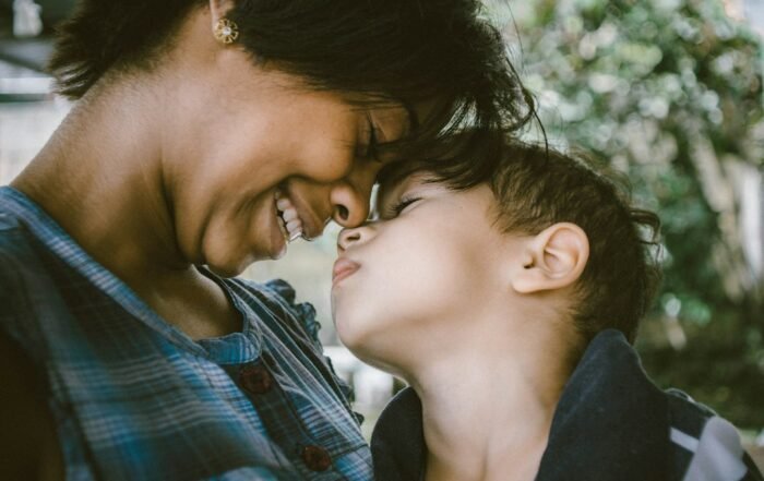Mãe e criança pequena encostando os rostos em um momento de calma e acolhimento