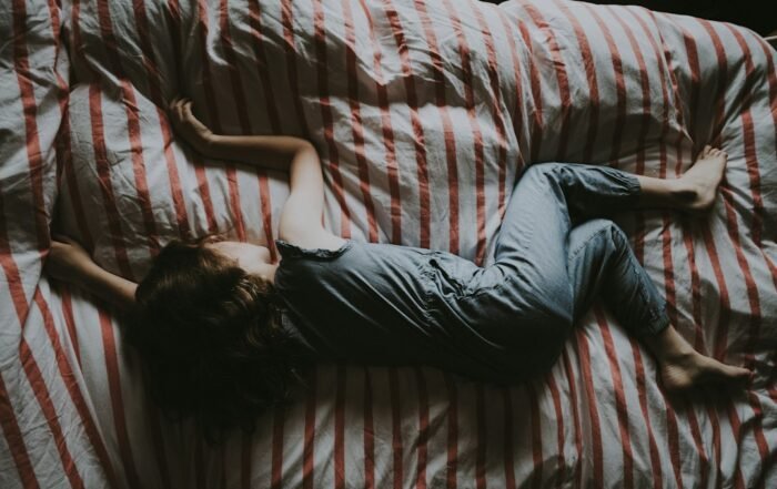 Criança dormindo tranquila na cama, em um quarto com luz baixa