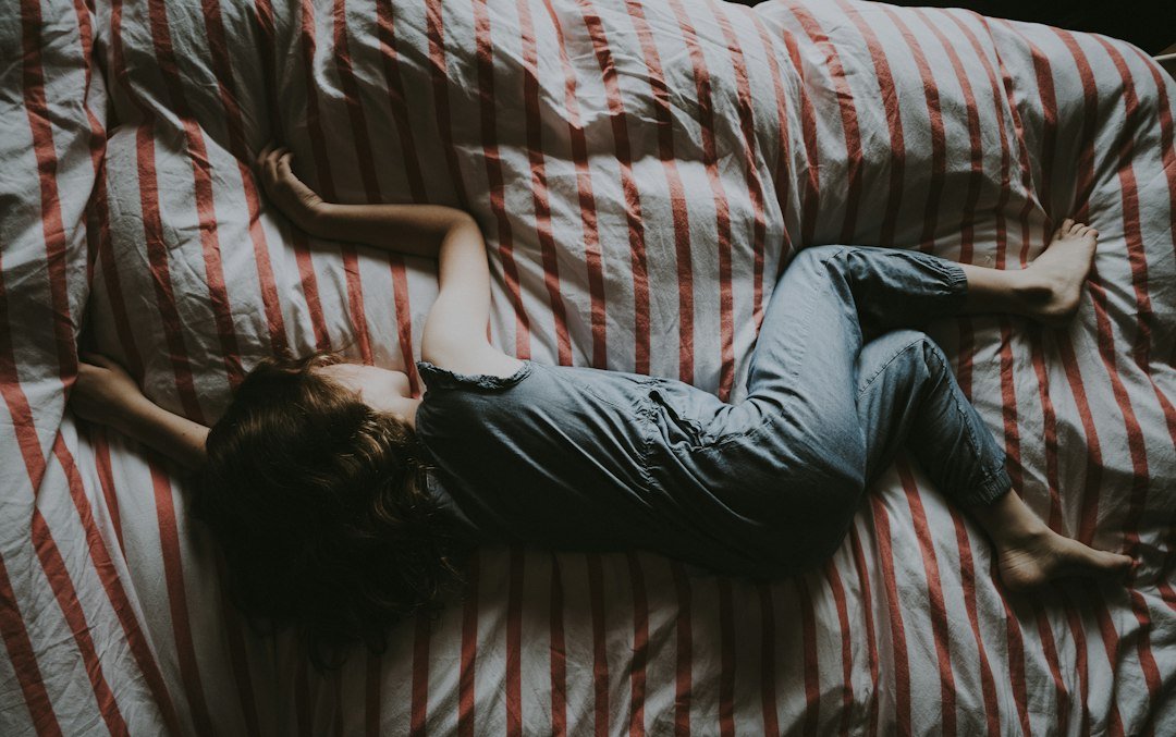 Criança dormindo tranquila na cama, em um quarto com luz baixa