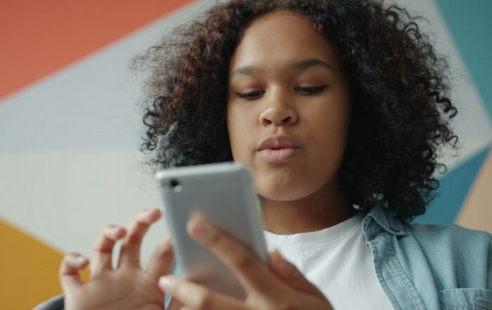 Adolescente em casa olhando a tela do celular