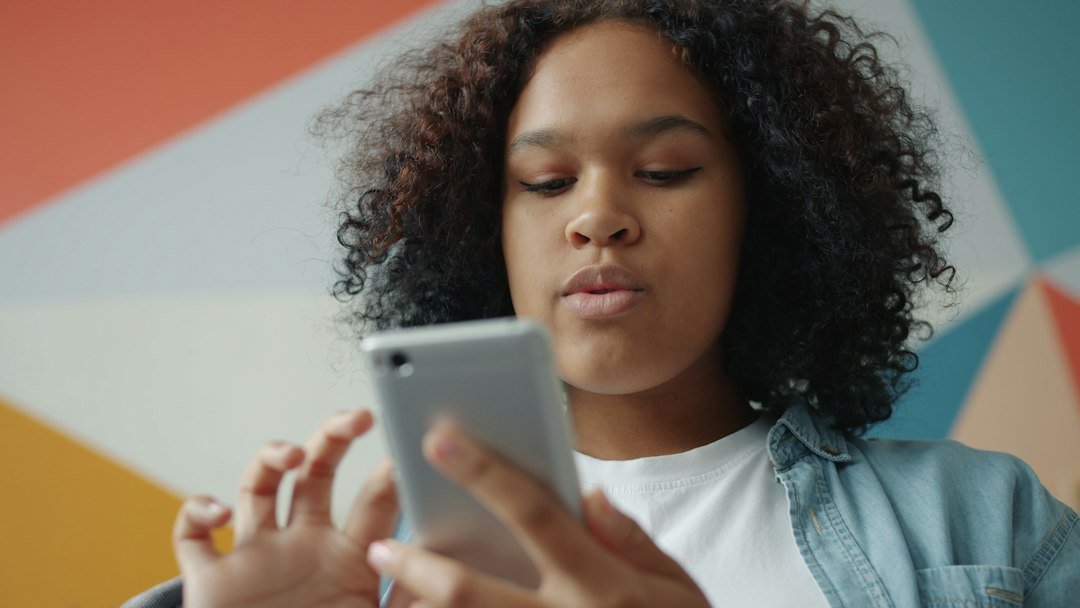 Adolescente em casa olhando a tela do celular